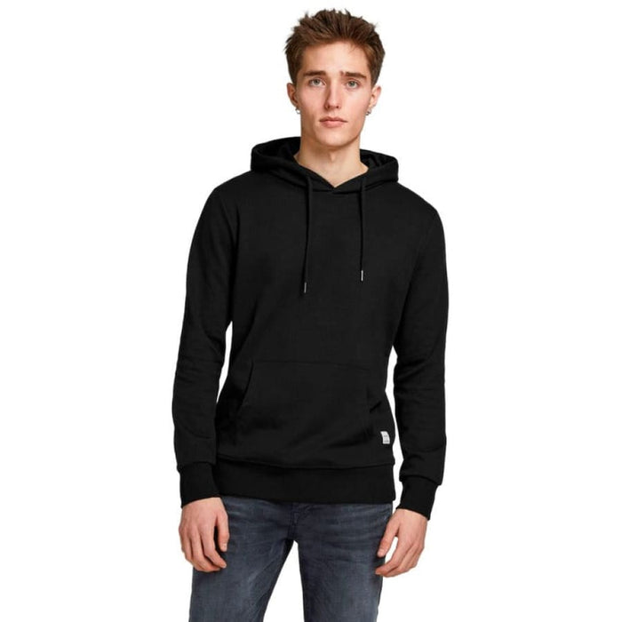 Man in Calvin Klein black hoodie, trendy Tommy Hilfiger pullovers.