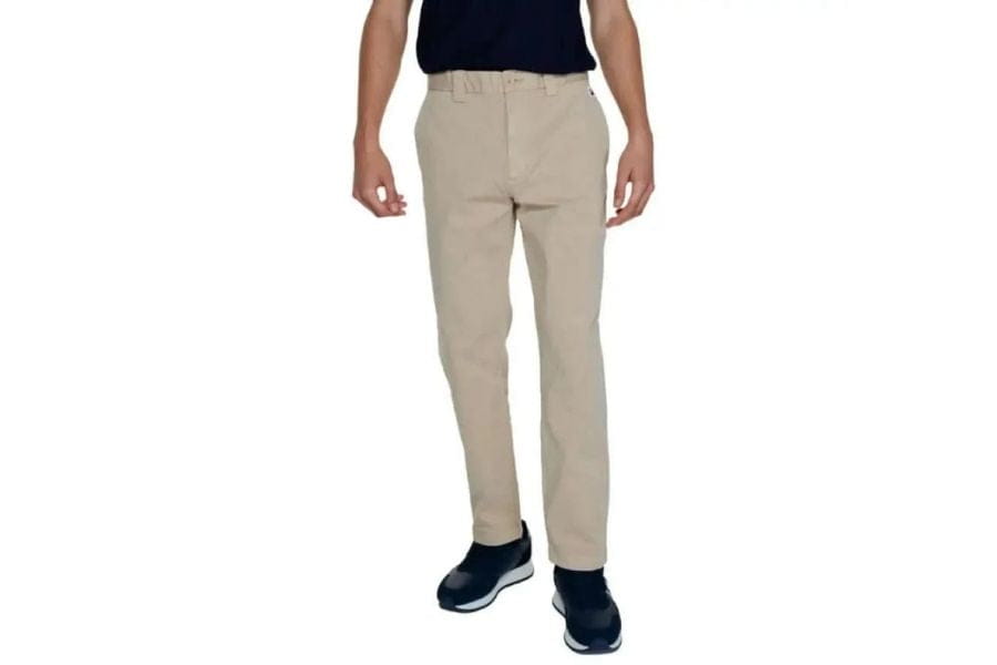 Beige chino pants worn by a person standing in a stylish men’s capsule wardrobe.