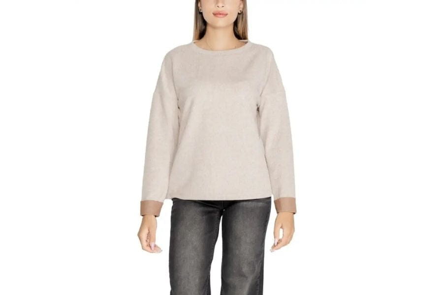 Beige long-sleeved sweater on a woman in a capsule wardrobe article.