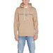 Beige Tommy Hilfiger hoodie with logo text worn over light blue distressed jeans