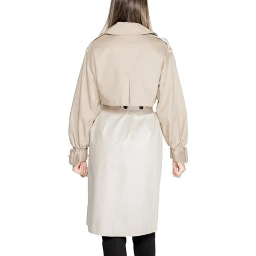 Beige trench coat with belted waist and puffed sleeves worn by a model from behind