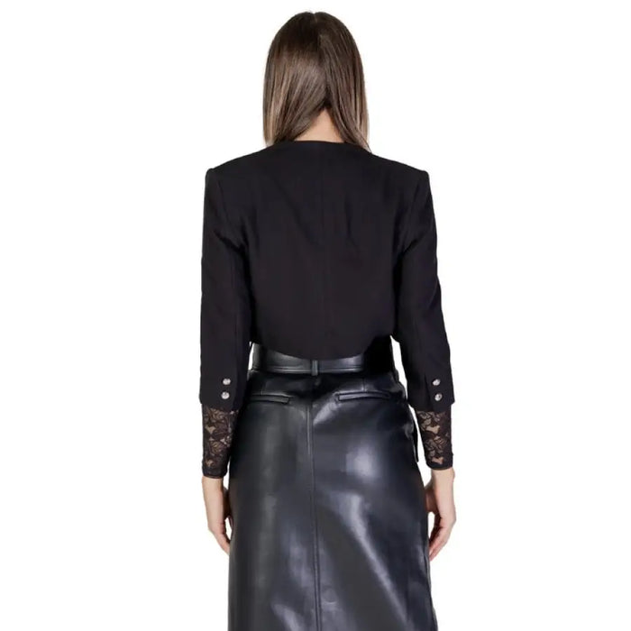 Black blazer with decorative sleeve cuffs paired with a leather skirt by Morgan De Toi