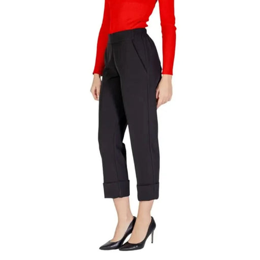 Black cropped dress pants with cuffed hems paired with red sweater and black heels