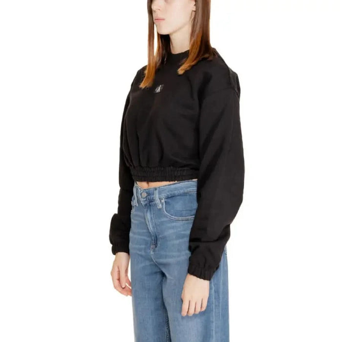 Calvin Klein black cropped sweatshirt paired with blue jeans for women