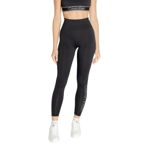 Black high-waisted athletic leggings featuring Calvin Klein branding on the leg