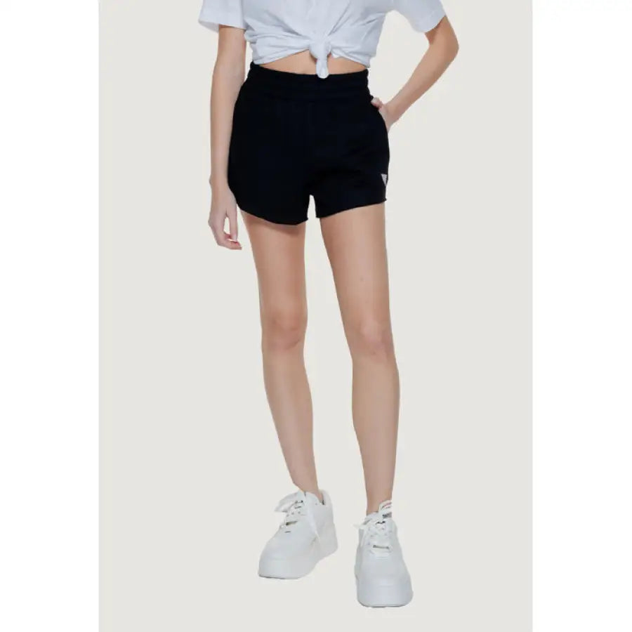 Guess Women Short: Black high-waisted shorts, cropped white top, white sneakers ensemble