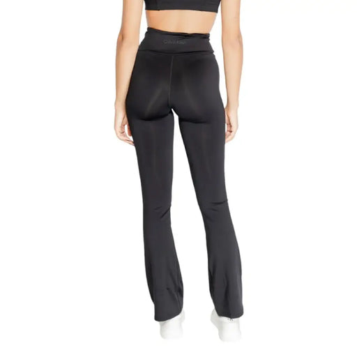 Black high-waisted flared yoga pants worn by a model featuring Calvin Klein Sport design