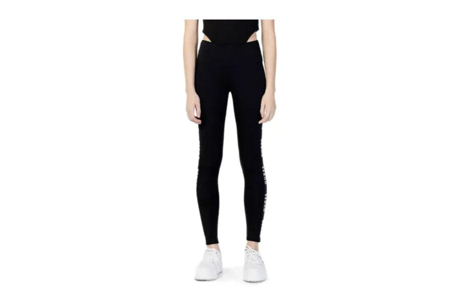 Black high-waisted leggings styled with white sneakers for minimalist apparel and accessories.