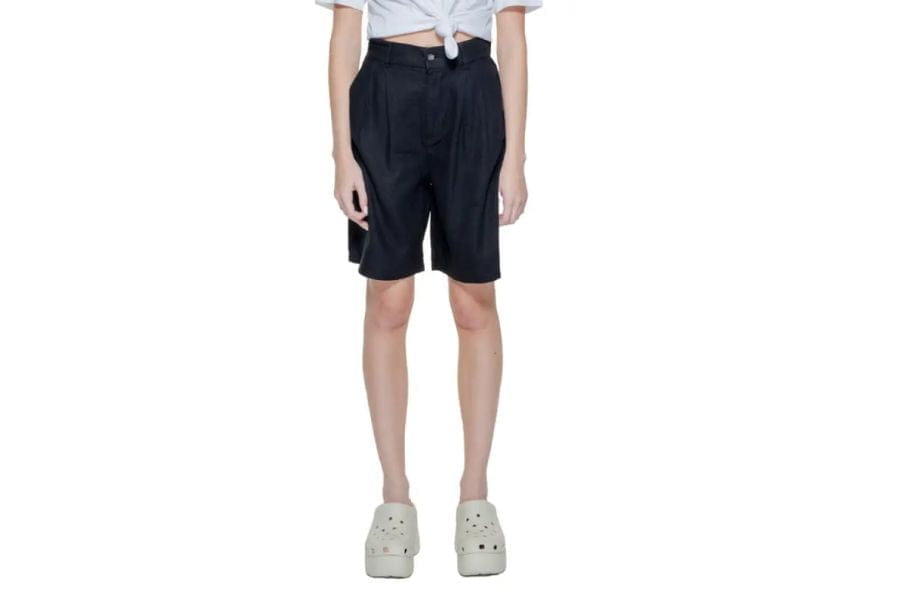 Black high-waisted shorts with white platform sneakers in summer work outfits.