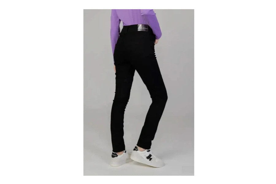 Black high-waisted skinny jeans with a purple top and white sneakers for minimalist apparel.