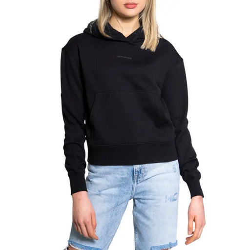 Black hooded sweatshirt over light blue distressed jeans from Calvin Klein Jeans collection