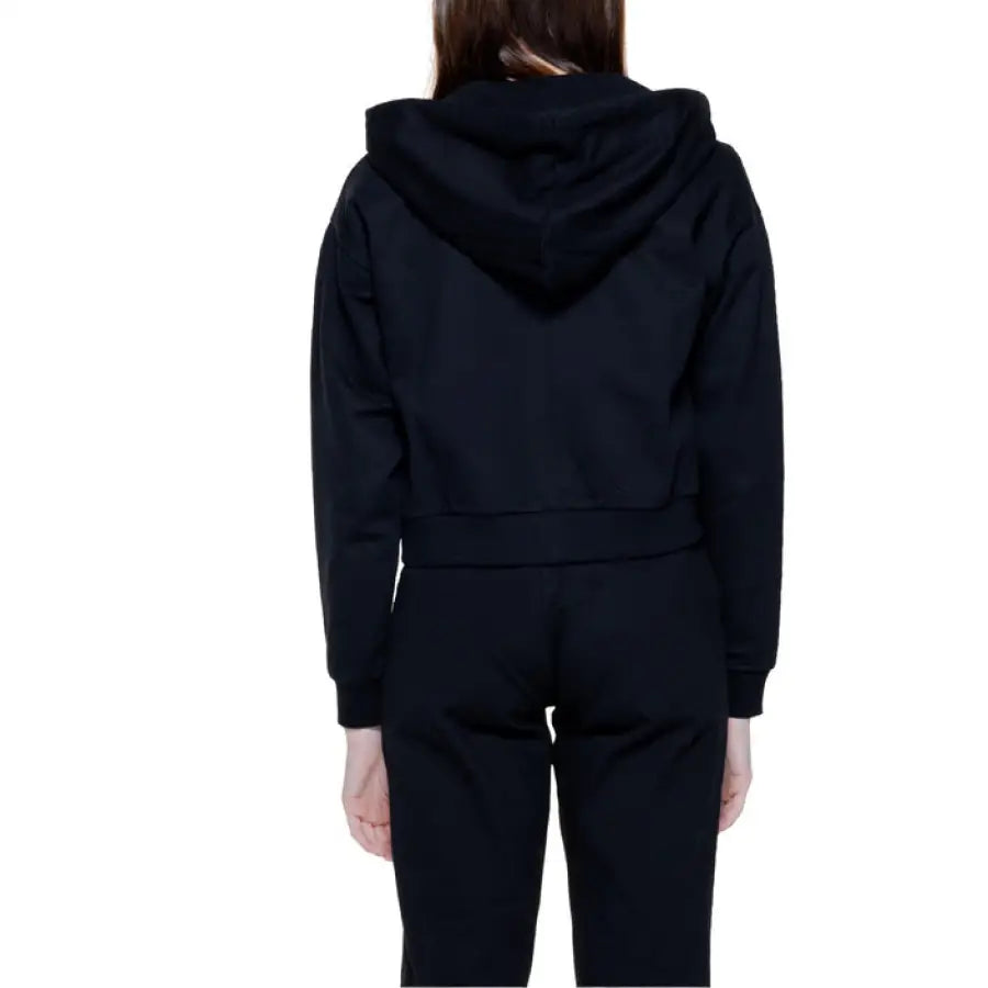 Person wearing Moschino Underwear Women’s black hooded sweatshirt, back view