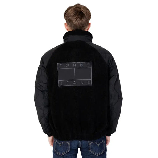 Black jacket featuring Tommy Jeans logo on the back, part of Tommy Hilfiger Jeans collection