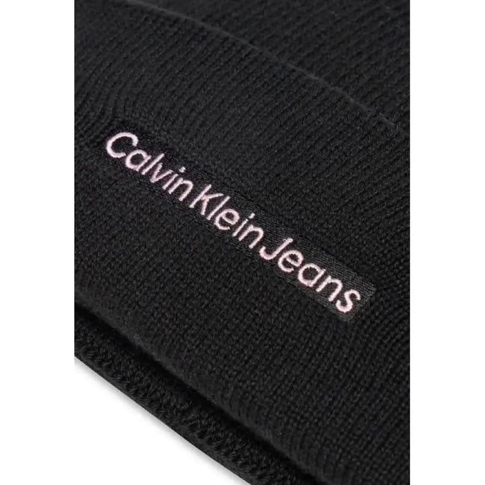 Black knit beanie featuring Calvin Klein Jeans embroidered in light pink text