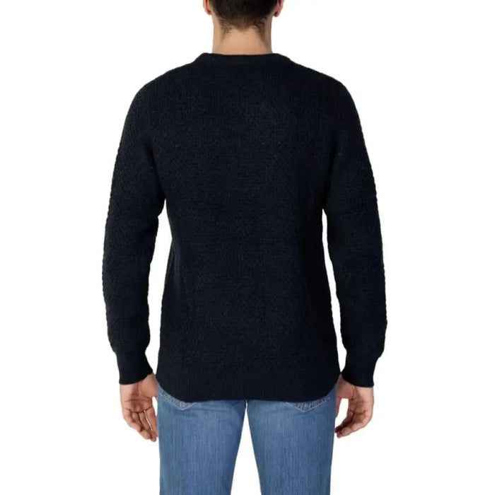 Black knit sweater on a person wearing blue jeans from the back - Selected Men Knitwear