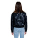 Calvin Klein black leather bomber jacket over light blue jeans, back view