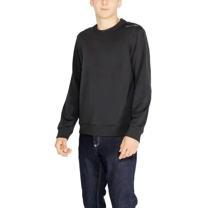 Black long-sleeved crewneck sweatshirt worn by model from Calvin Klein Sport Men collection