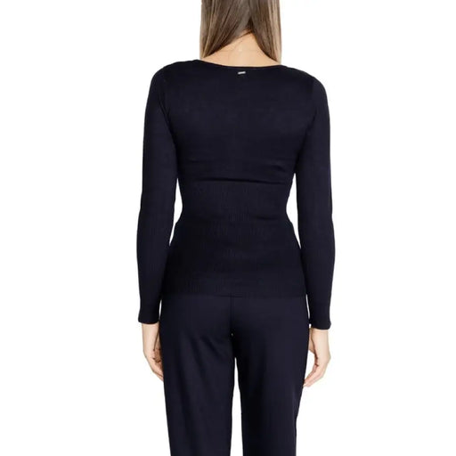 Black long-sleeved top by Morgan De Toi worn by a woman, viewed from behind