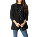 Black oversized blazer with three-quarter sleeves worn over patterned top and blue jeans