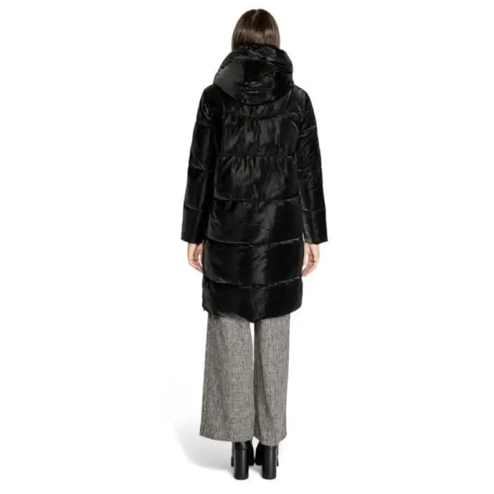 Black quilted puffer coat with hood styled over gray pants and boots from Cleré