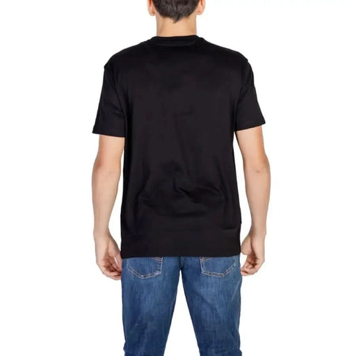 Black short-sleeved Armani Exchange Men T-Shirt worn by a person facing away