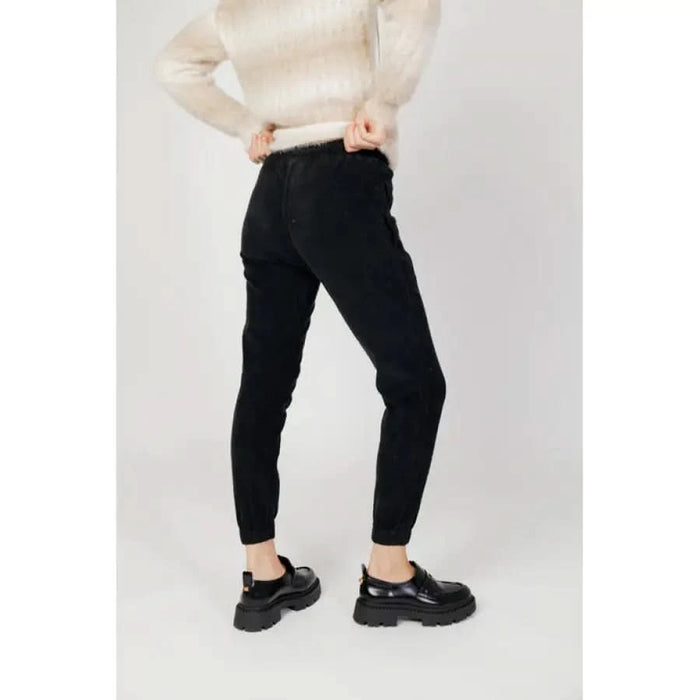 Black skinny pants paired with a cream sweater and black shoes in Hanny Deep Women Trousers