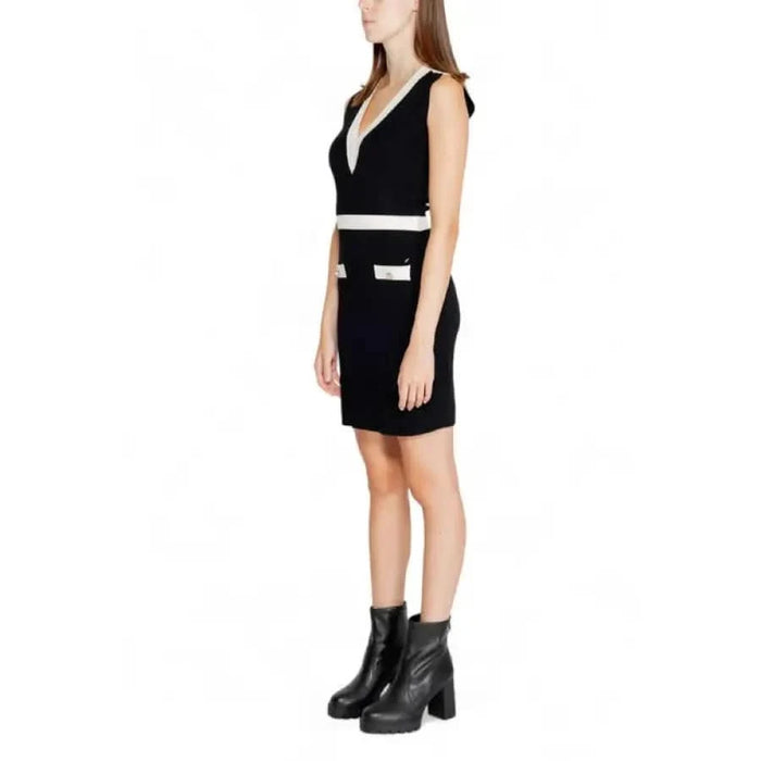 Black sleeveless mini dress with white trim and plunging neckline by Morgan De Toi