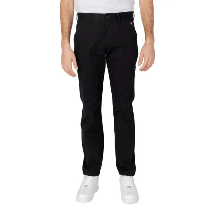 Tommy Hilfiger black straight-leg trousers paired with white sneakers for men