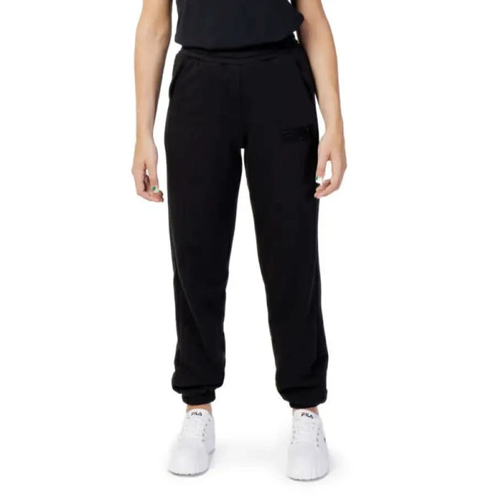 Black Fila Women Trousers styled as joggers worn by a standing individual