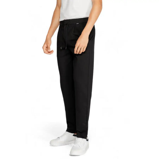 Black drawstring sweatpants with straight legs worn with white sneakers by Calvin Klein Men Trousers