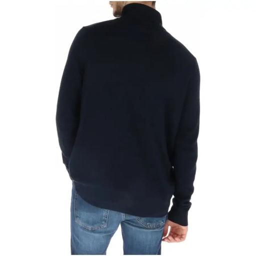 Black turtleneck sweater paired with blue jeans from Lyle & Scott Men Knitwear