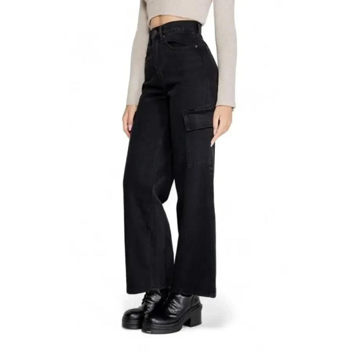 Black wide-leg cargo pants with pockets styled with chunky platform shoes by Only