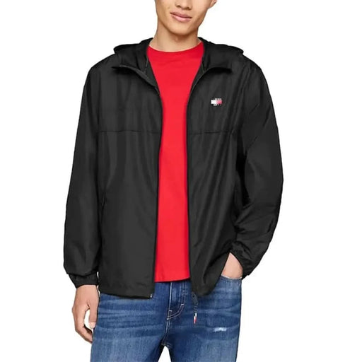 Black zip-up Tommy Hilfiger jacket over a red t-shirt showcasing a small logo