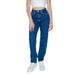 Stylish blue denim jeans paired with a white crop top and white sneakers by Calvin Klein