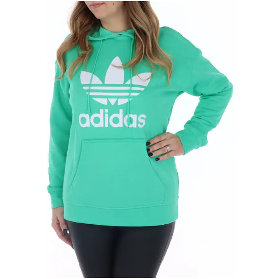 Bright teal Adidas women’s sweatshirt with white trefoil logo and text
