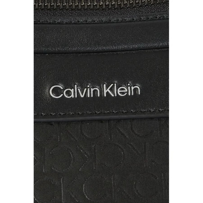 Calvin Klein logo on black textured surface of Calvin Klein Men Bag