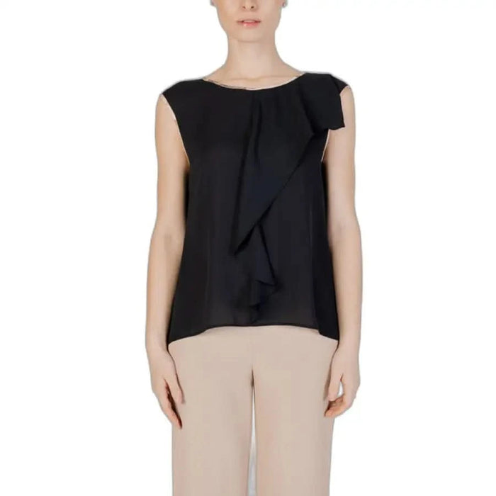 Woman in Alviero Martini Prima Classe black top and beige pants close up