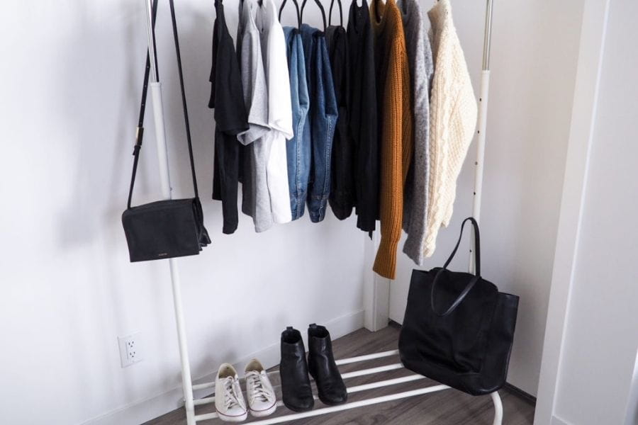 Clothing rack displaying diverse garments and accessories for a capsule wardrobe.