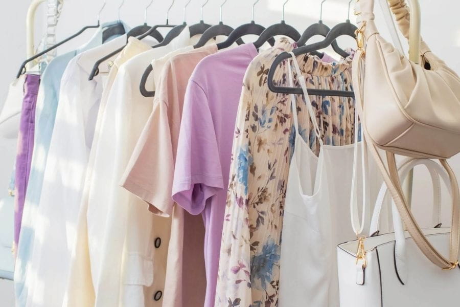 Clothing rack displaying assorted garments and accessories for a capsule wardrobe.