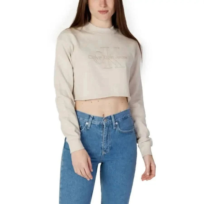 Cropped beige Calvin Klein Jeans sweatshirt with high-waisted blue jeans for women