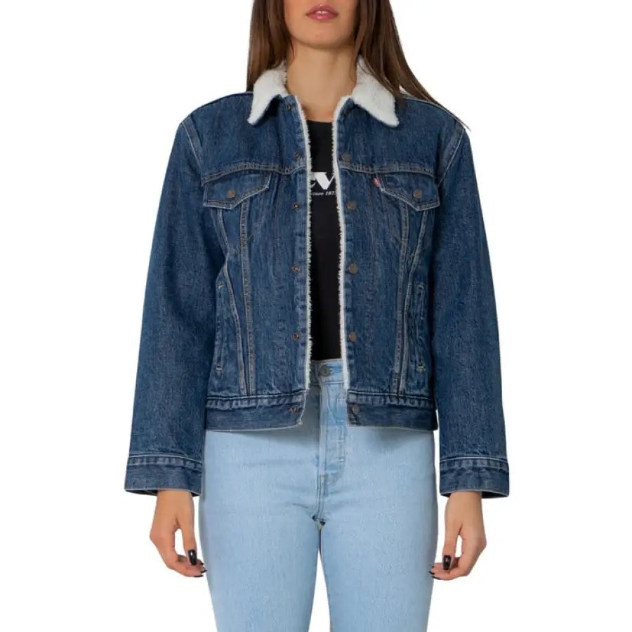 Levi’s women’s denim jacket with white sherpa collar over black top and light blue jeans