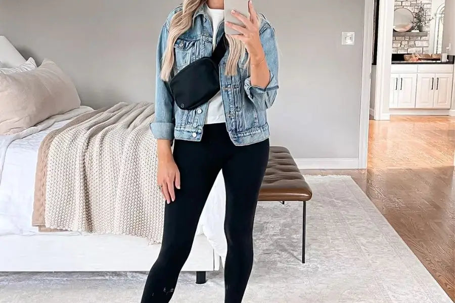 Denim jacket over white top, black pants, and fanny pack for a first date outfit.