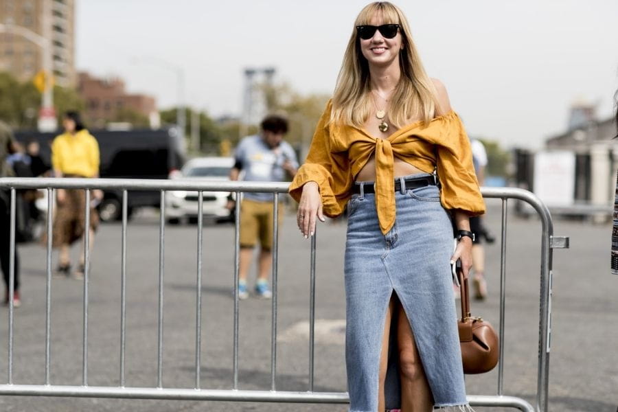 Denim maxi skirt with front slit and mustard yellow tie-front crop top outfit.