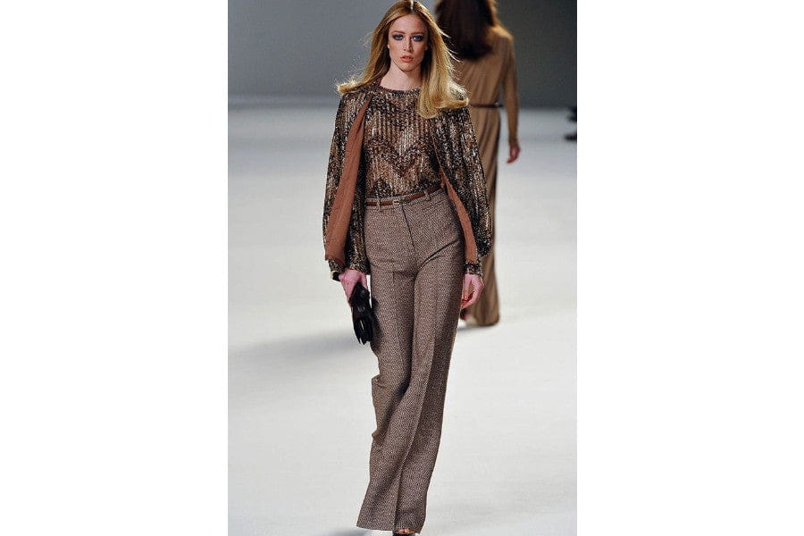 Fashion model showcasing a trend in 70s style with a brown sequined top and trousers.