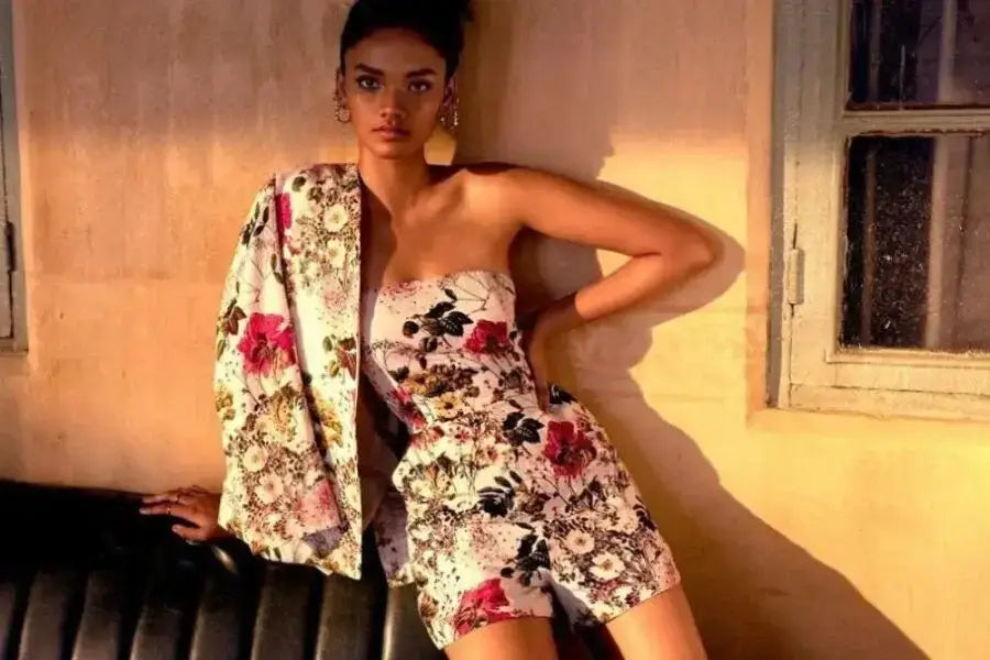 Floral gemustertes trägerloses Minikleid mit passender Jacke als Inspiration für ein Urlaubsoutfit.