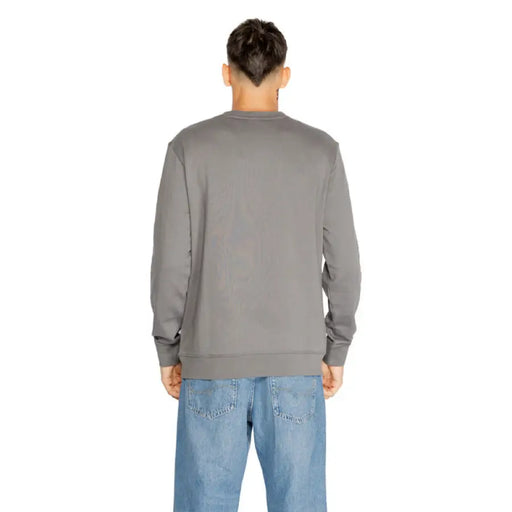 Gray long-sleeved sweatshirt worn by a person from behind in Boss Men Knitwear collection