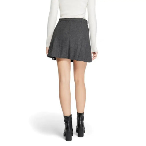 Gray pleated mini skirt paired with white top and black ankle boots from Only Women