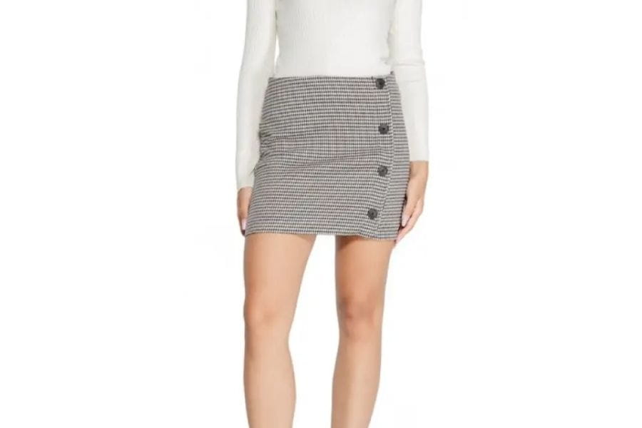 Houndstooth patterned mini skirt with side buttons for retro fashion statement.