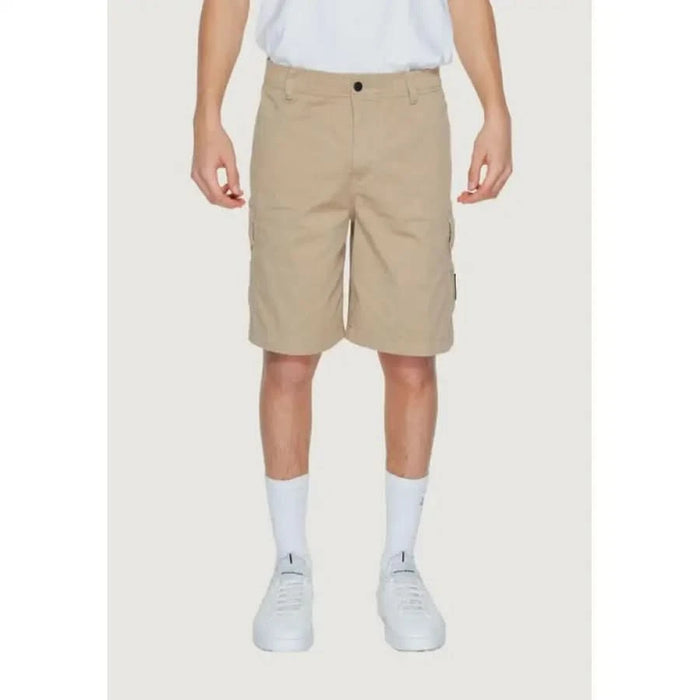 Khaki cargo shorts by Calvin Klein Jeans worn with white shirt and sneakers