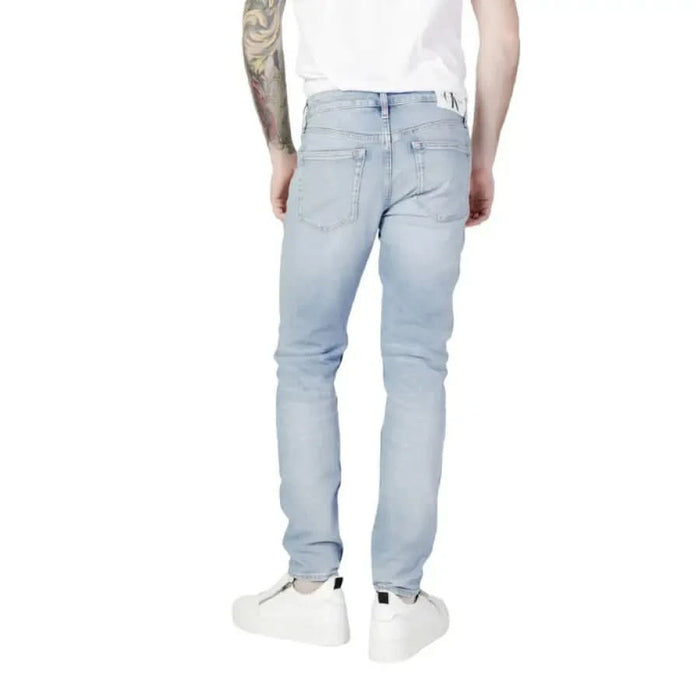 Light blue denim jeans worn by a person with tattoos, Calvin Klein Jeans Men